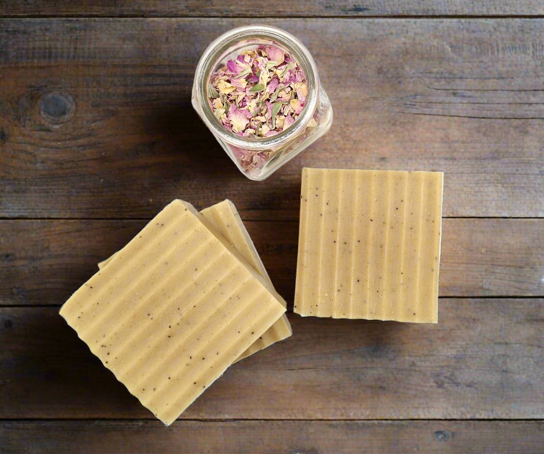 NoCo Apothecary tallow soap on wood table with rose petals